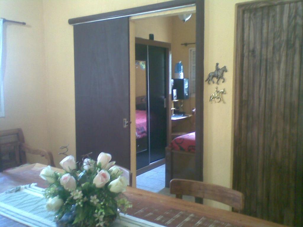 um quarto com uma mesa com um vaso de flores em Pousada Vila Verde em Tiradentes