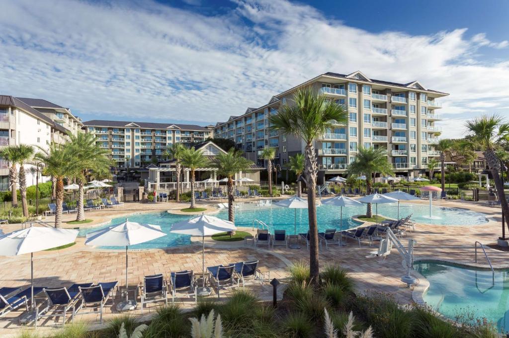 an image of a resort pool with chairs and umbrellas at Hilton Grand Vacations Club Ocean Oak Resort Hilton Head in Hilton Head Island