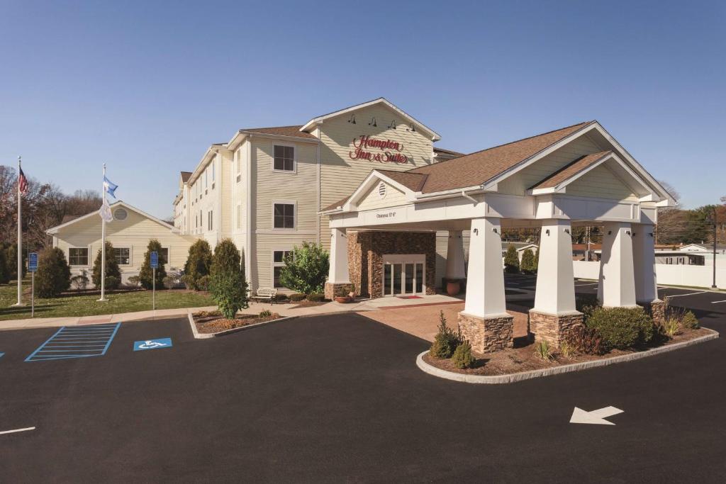 a front view of a hotel with a parking lot at Hampton Inn & Suites Mystic in Mystic