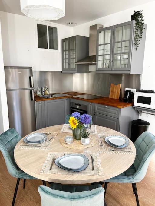 une cuisine avec une table sur laquelle sont posées des assiettes et des fleurs dans l'établissement La Capitainerie, au Tréport