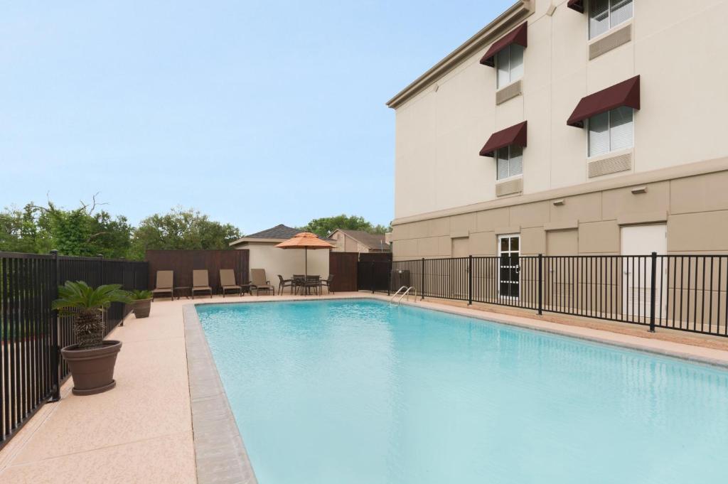 a swimming pool in front of a building at Hawthorn Extended Stay by Wyndham College Station in College Station