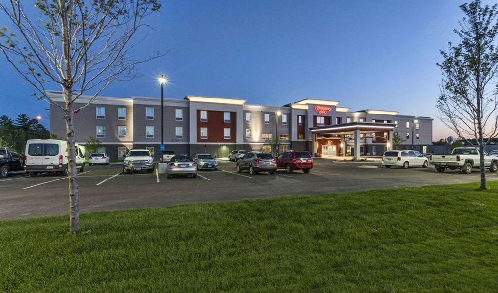 a parking lot with cars parked in front of a building at Hampton Inn Hibbing in Hibbing