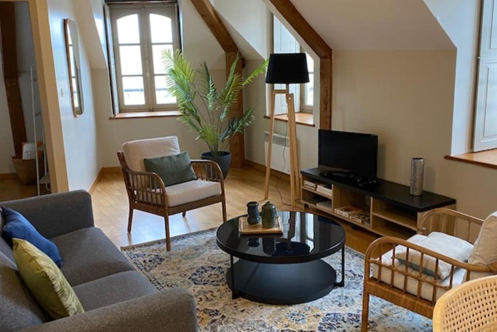 a living room with a couch and a table at Bright apartment near the heart of Vannes in Vannes