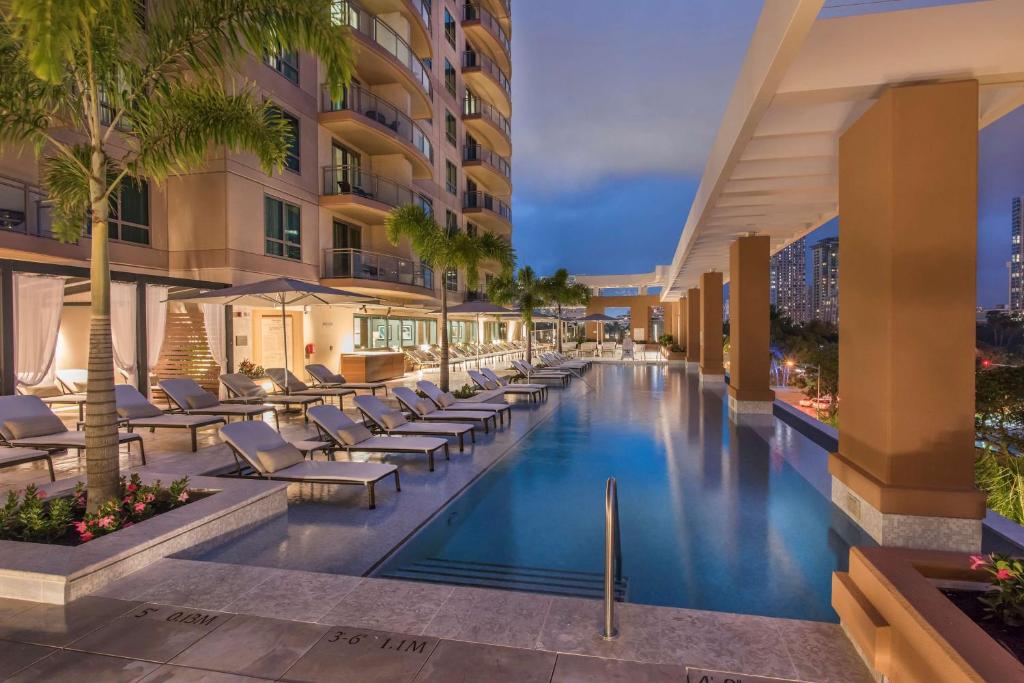 een afbeelding van een hotelzwembad met ligstoelen en palmbomen bij Hilton Grand Vacation Club The Grand Islander Waikiki Honolulu in Honolulu