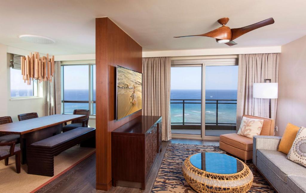 - un salon avec un canapé et une table avec vue dans l'établissement Hilton Grand Vacation Club The Grand Islander Waikiki Honolulu, à Honolulu