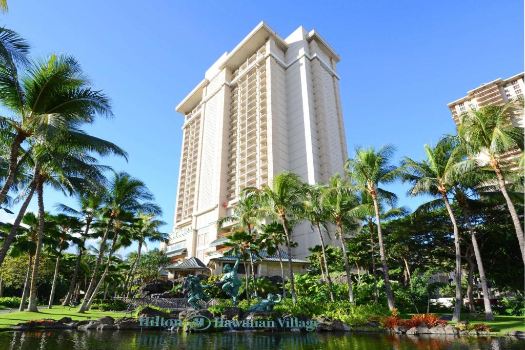 a tall building with palm trees in front of it at Hilton Grand Vacations Club at Hilton Hawaiian Village in Honolulu