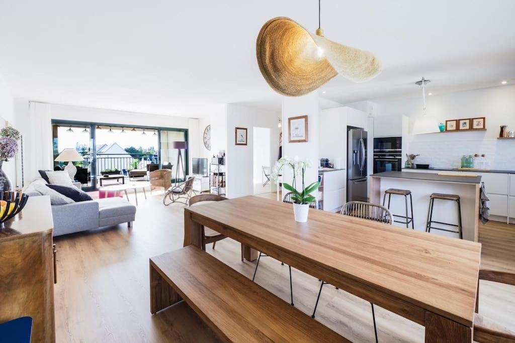 a living room with a dining table and a kitchen at Superbe appartement de 120m2 et 2 balcons, à 10min à pieds de la plage - 3 chambres - parking privé in Le Pouliguen