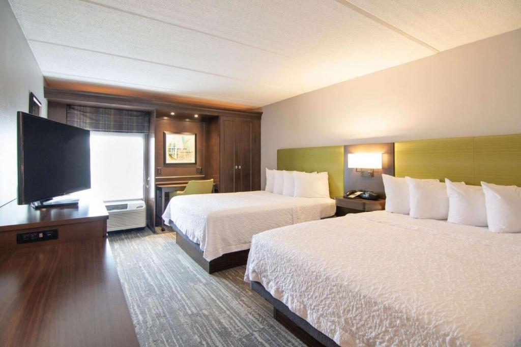 a hotel room with two beds and a flat screen tv at Hampton Inn Houston I-10 West-Energy Corridor in Houston
