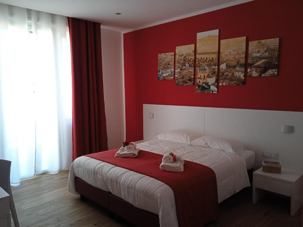 ein Schlafzimmer mit einem weißen Bett mit roten Wänden in der Unterkunft Room and Breakfast San Marco in Bologna