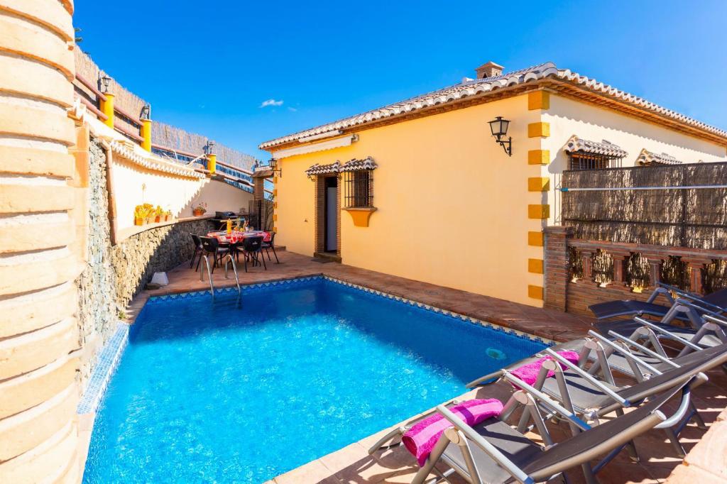 - une piscine avec des chaises et une maison dans l'établissement Villa Las Palomas 2, à Frigiliana