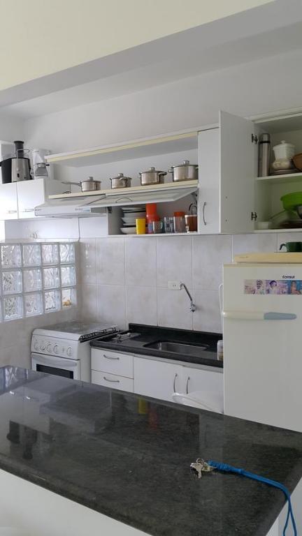 a kitchen with white cabinets and a stove at Dom Pedro 54 in Guarujá
