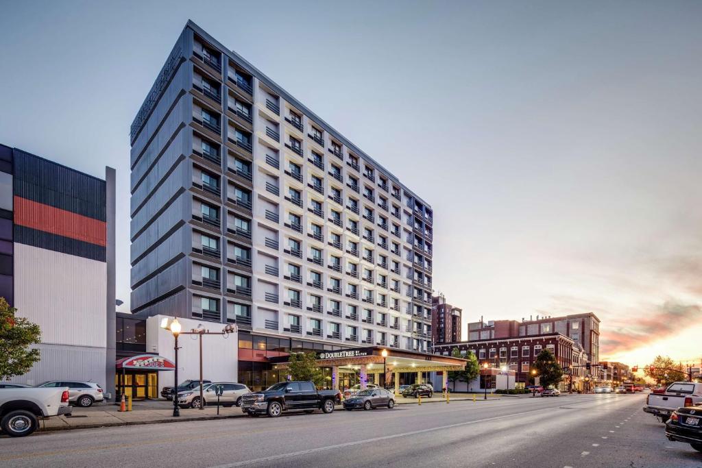 un grand bâtiment avec des voitures garées en face d'une rue dans l'établissement DoubleTree by Hilton Huntington, WV, à Huntington