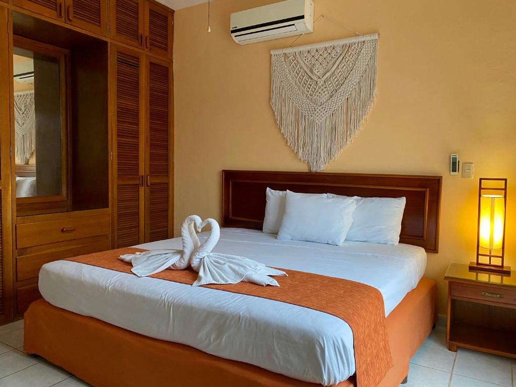 a bedroom with a bed with two towels on it at Quinta Sea in Playa del Carmen