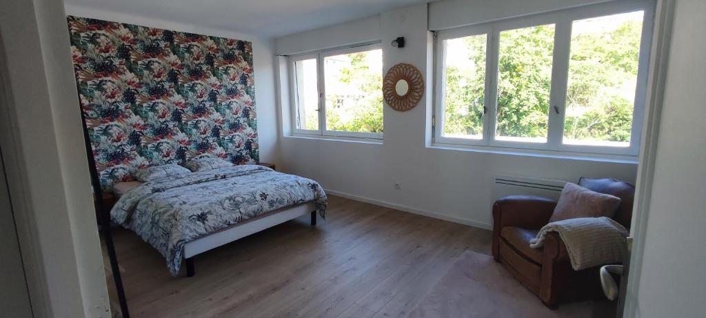 a bedroom with a bed and a chair and two windows at Bel appartement lumineux 3 chambres in Lay-Saint-Christophe