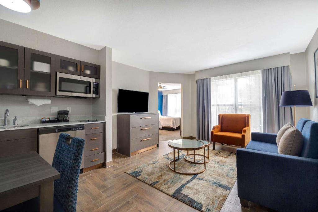 a hotel room with a kitchen and a living room at Homewood Suites by Hilton Jackson-Ridgeland in Ridgeland