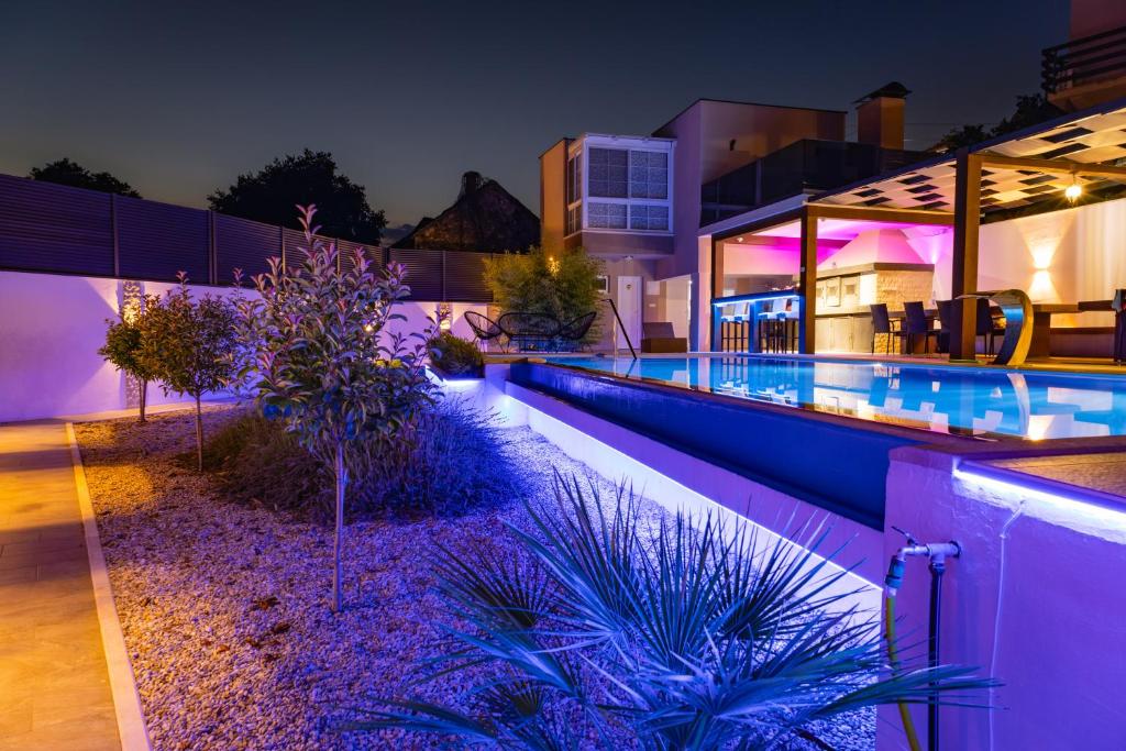 uma piscina à noite com luzes roxas em Holiday Home Korda em Capljina