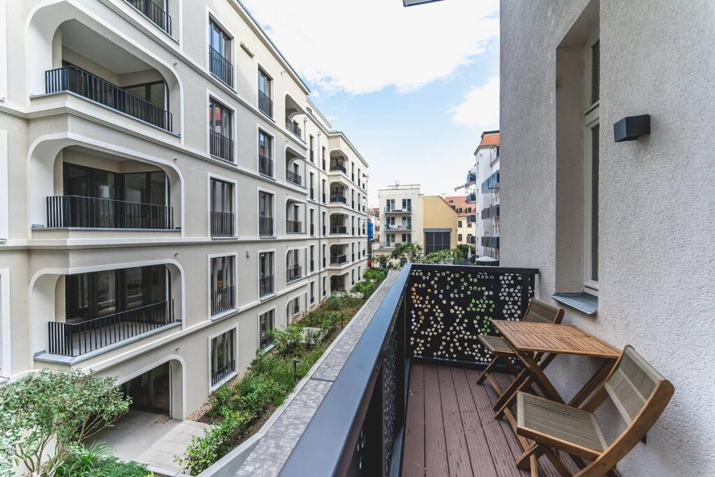 einen Balkon mit 2 Stühlen und einem Holztisch in der Unterkunft TIP! Geräumiges Apartment direkt im Stadtzentrum für 6 Personen in Dresden