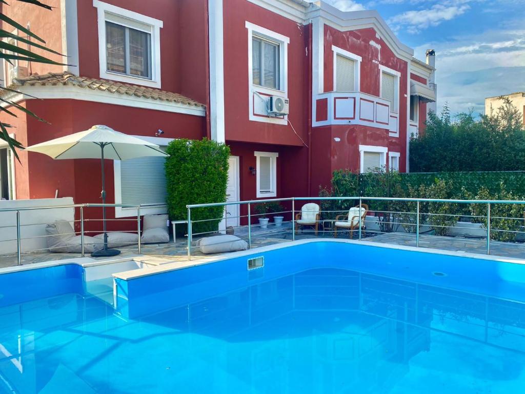 a swimming pool in front of a building at Corfu Villa Kanoni in Kanoni