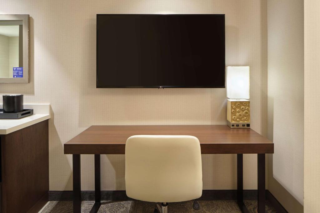 a room with a desk with a chair and a television at Embassy Suites By Hilton Oahu Kapolei - FREE Breakfast in Kapolei