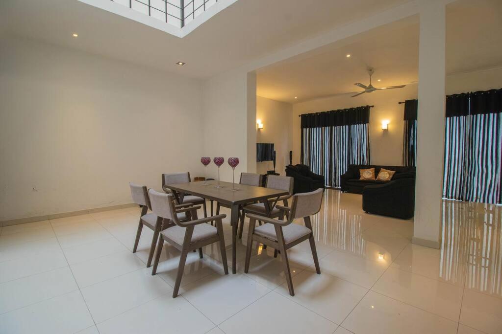 a dining room table and chairs in a living room at Stylish 4BR+3.5BA home wt AC + Rooftop + Parking in Moratuwa