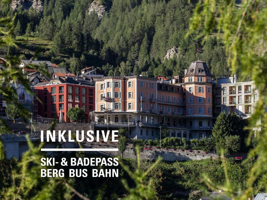 a group of buildings in front of a mountain at Hotel Belvedere Scuol in Scuol
