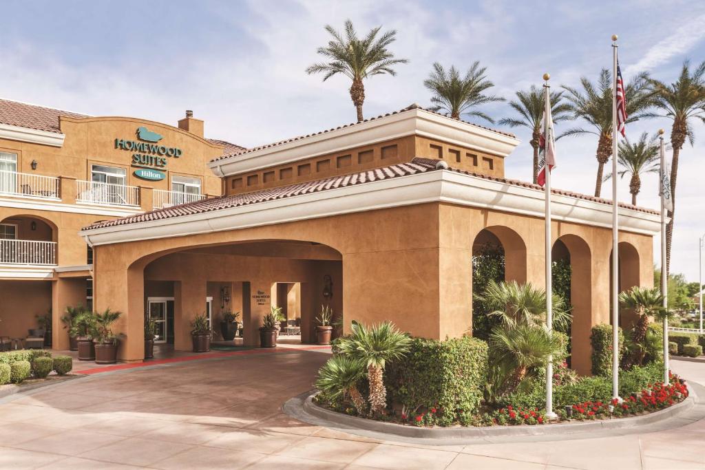 a hotel with palm trees in front of a building at Homewood Suites by Hilton La Quinta in La Quinta