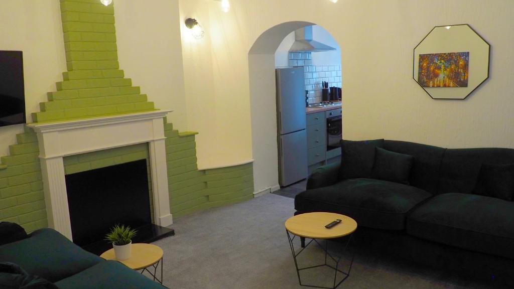 sala de estar con sofá y chimenea en Emerald House - TV in every bedroom!, en Neath