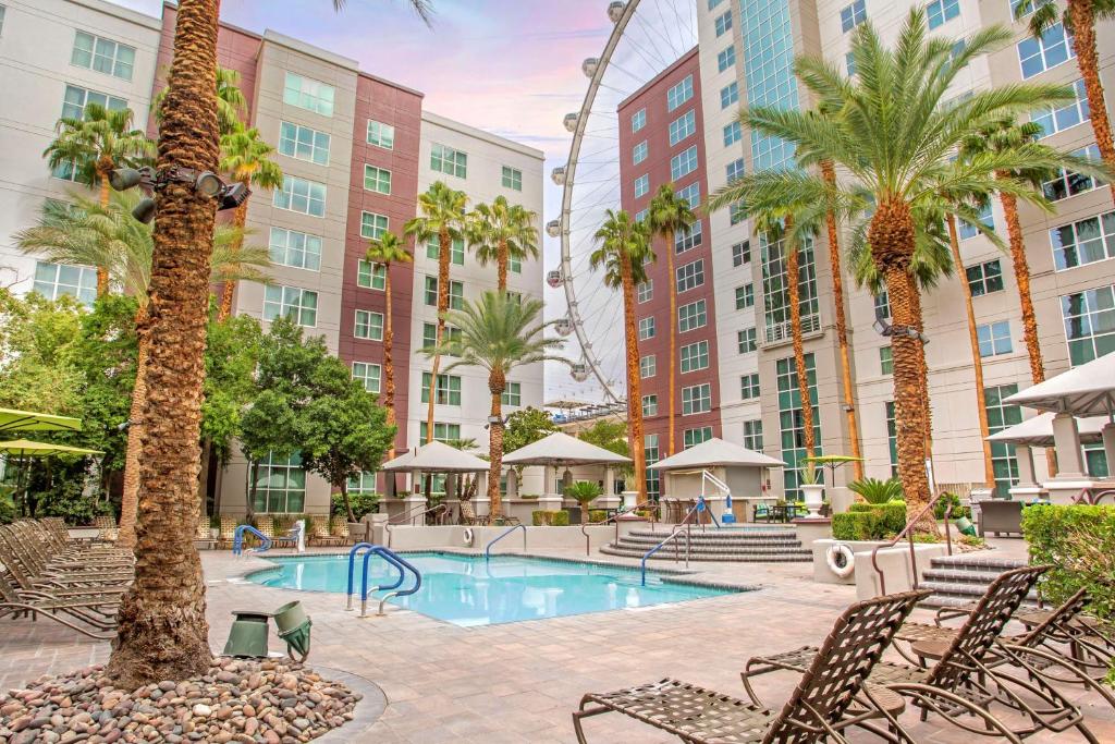a pool with chairs and palm trees and buildings at Hilton Grand Vacations Club Flamingo Las Vegas in Las Vegas