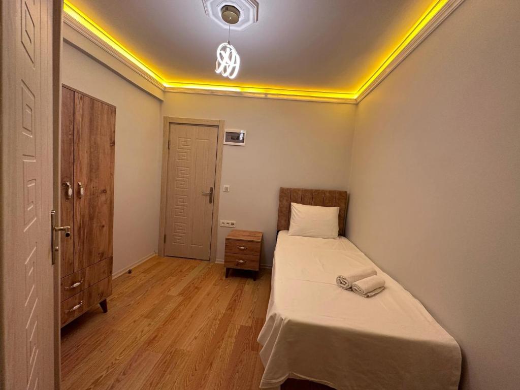 um pequeno quarto com uma cama e um tecto amarelo em pilot hotel em Arnavutköy