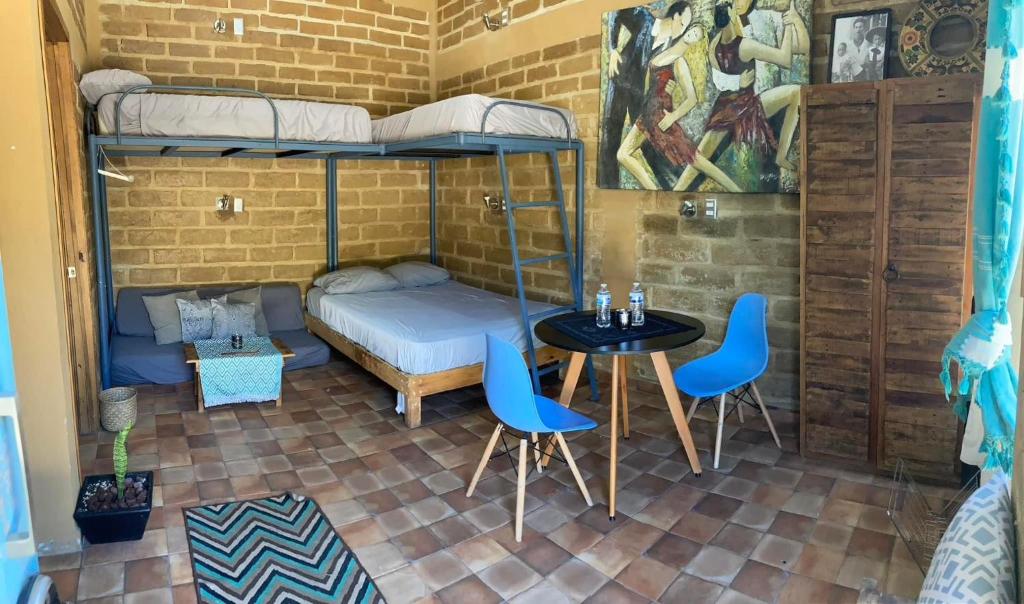 a room with a bunk bed and a table and chairs at Estudio en la Montaña in Tepoztlán