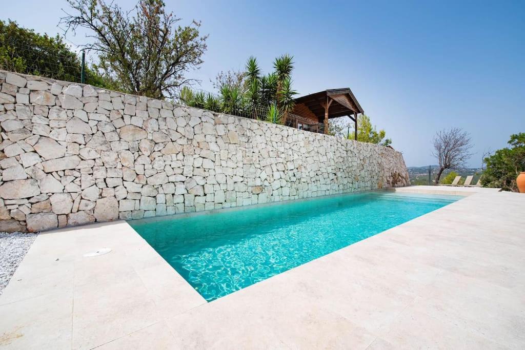 een stenen muur naast een zwembad bij Villa estilo Mediterráneo in Calpe