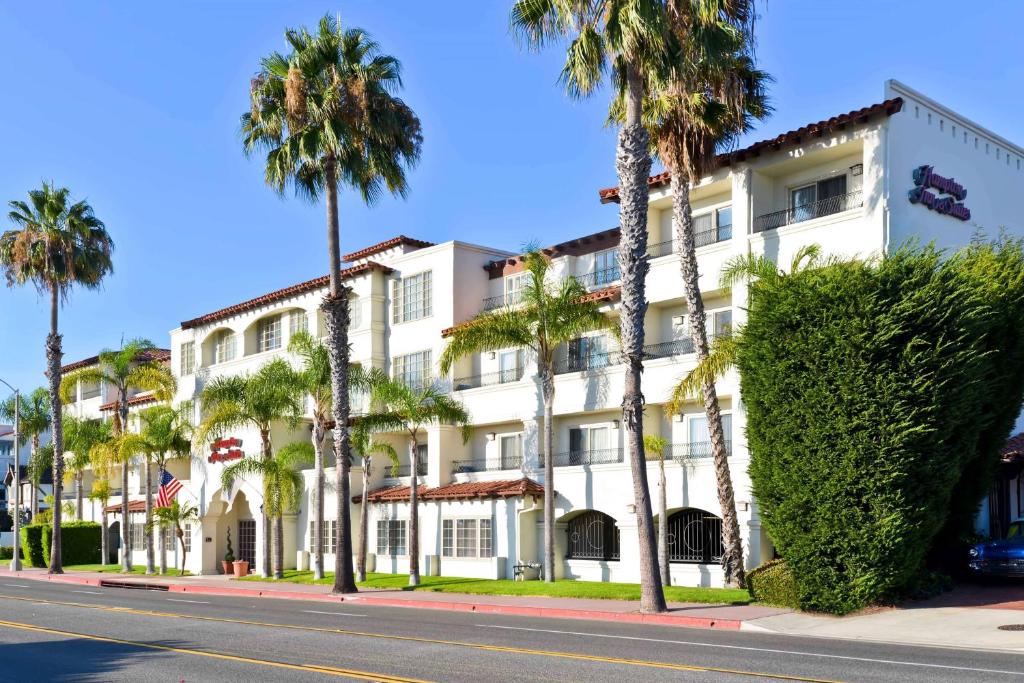 ein weißes Gebäude mit Palmen an der Straßenseite in der Unterkunft Hampton Inn & Suites San Clemente in San Clemente