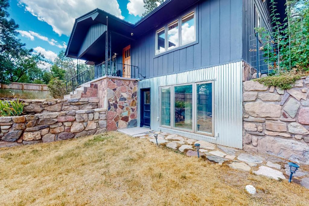 ein Haus mit einer Steinmauer und einer blauen Tür in der Unterkunft Narrow Gauge Nook in Durango