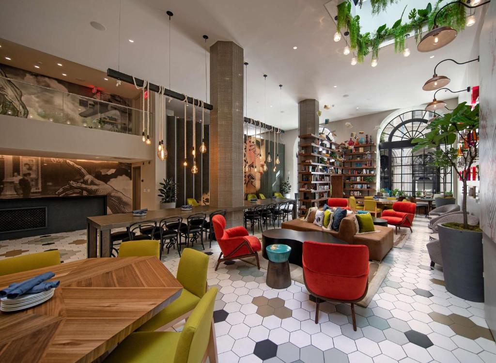 a restaurant with colorful chairs and tables in a room at The Wayfarer Downtown LA, Tapestry Collection by Hilton in Los Angeles