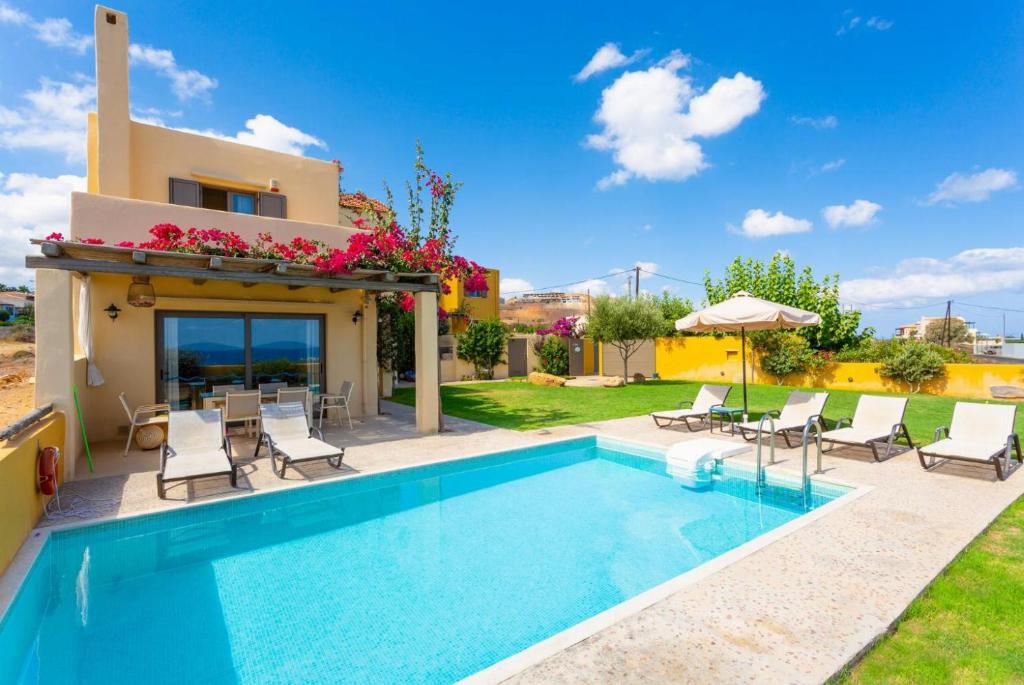 eine Villa mit einem Pool und einem Haus in der Unterkunft Panormos Villas Collection in Panormos