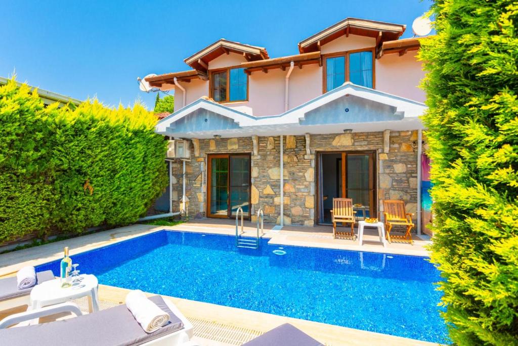 a villa with a swimming pool and a house at Villa Deniz Paradise in Dalyan