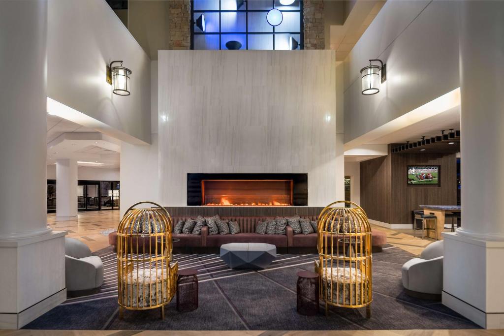 a living room with a couch and a fireplace at Hilton Lexington Downtown in Lexington