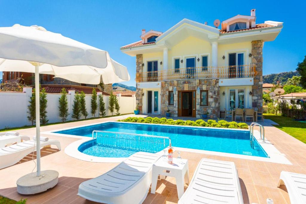 a villa with a swimming pool and a house at Villa Portakal Blossom in Dalyan