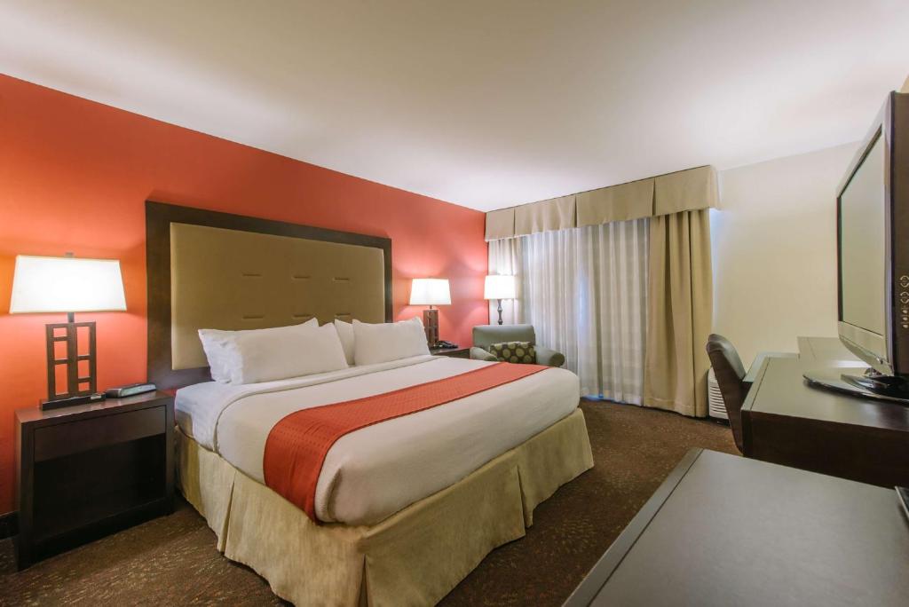 a hotel room with a large bed and a desk at Hotel MTK Mount Kisco in Mount Kisco