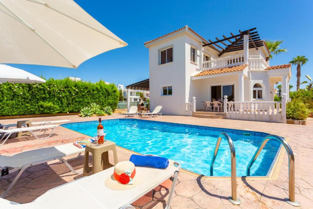 a villa with a swimming pool and a house at Queens Paradise 1 in Peyia