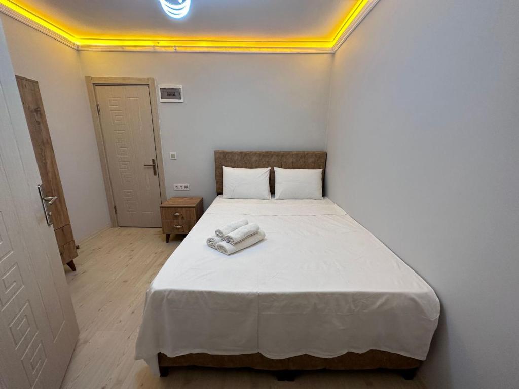 a small bedroom with a bed with a white blanket at pilot hotel in Arnavutköy