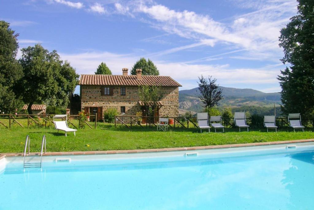 a large swimming pool in front of a house at Casale Donatelli in Radicofani