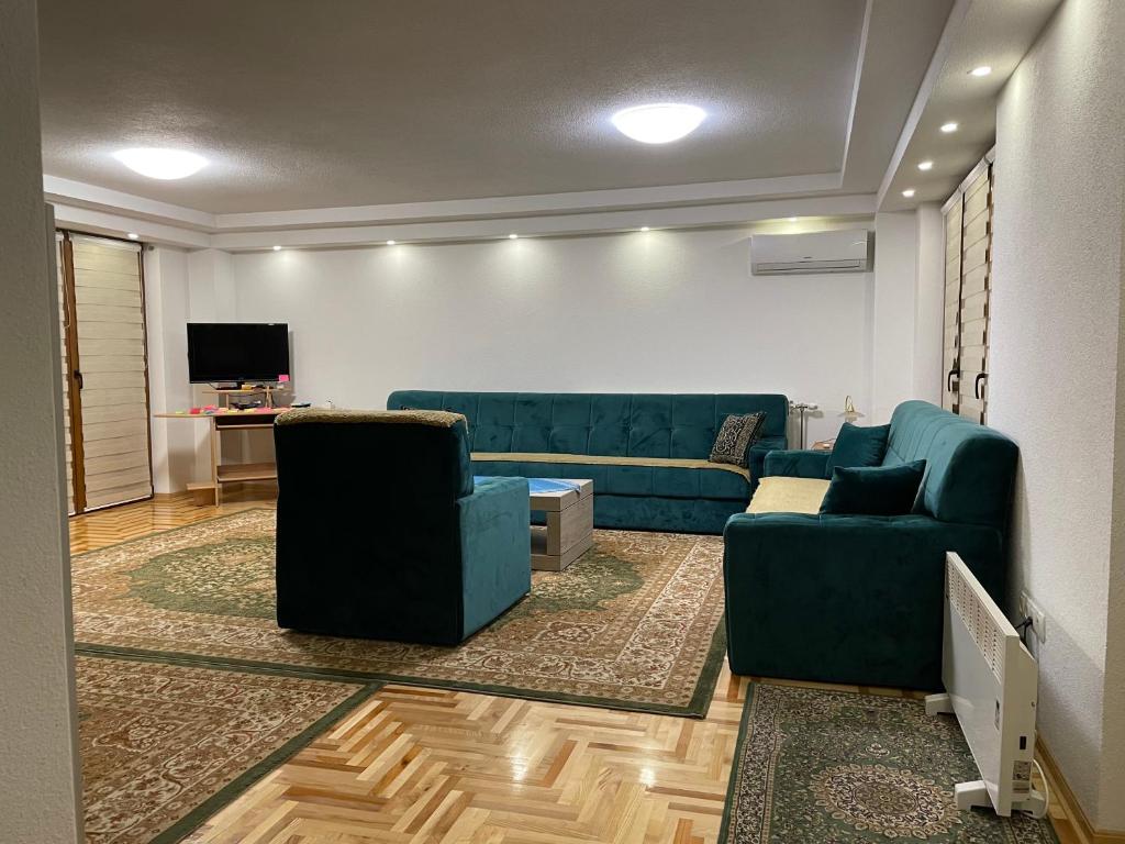 uma sala de estar com dois sofás azuis e uma televisão em Exclusive apartments Visoko 2022 em Visoko