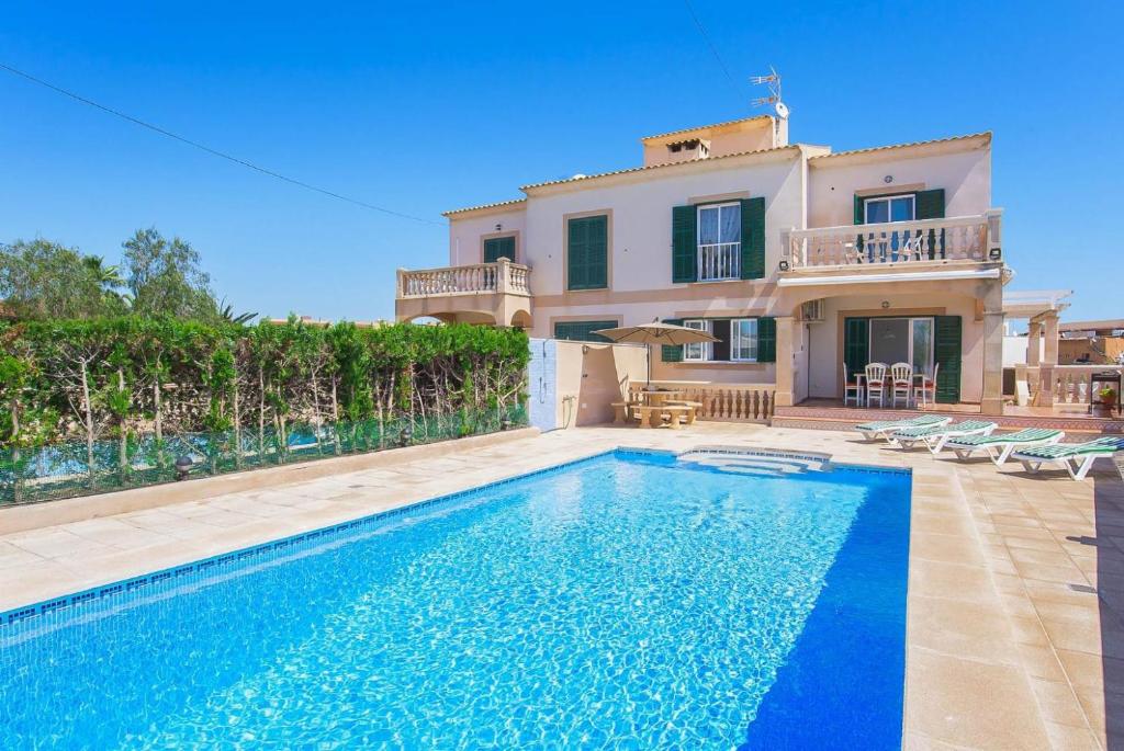 a villa with a swimming pool in front of a house at Villa Alicia in Portocolom