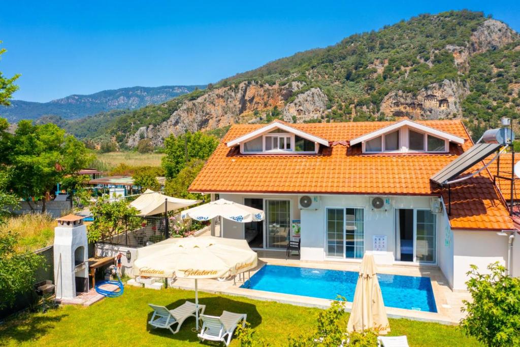 a villa with a swimming pool and mountains in the background at Villa Zonkdemir in Dalyan