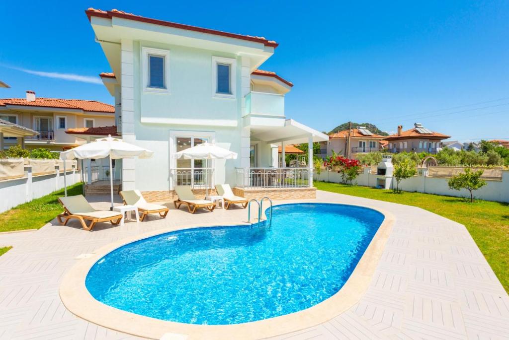 a villa with a swimming pool in front of a house at Villa Veli in Dalyan