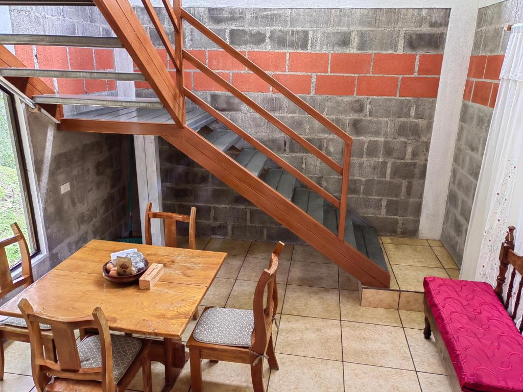 une salle à manger avec une table et un escalier dans l'établissement Monteverde Monte Green, à Monteverde Costa Rica