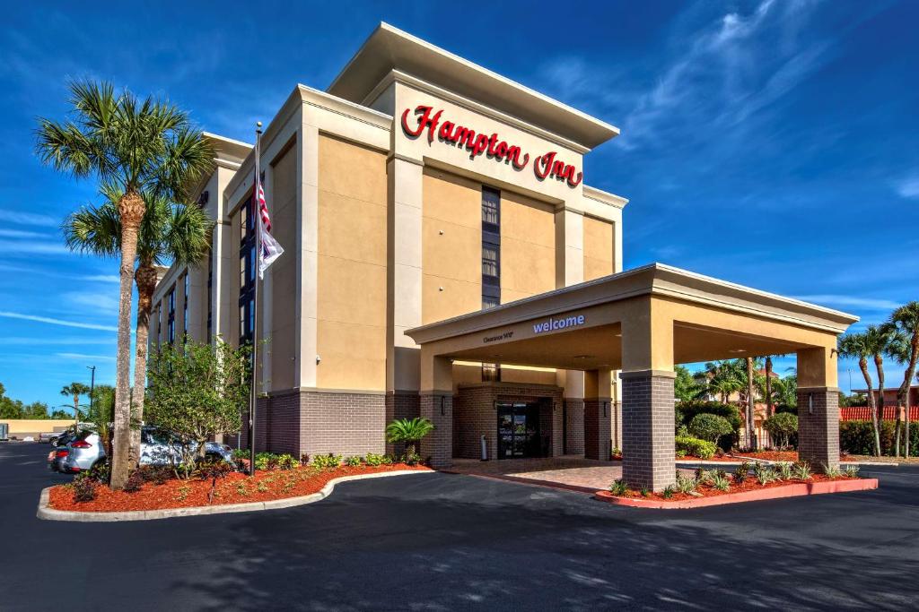 a shopping center with a sign on the front of it at Hampton Inn Orlando-Maingate South in Davenport