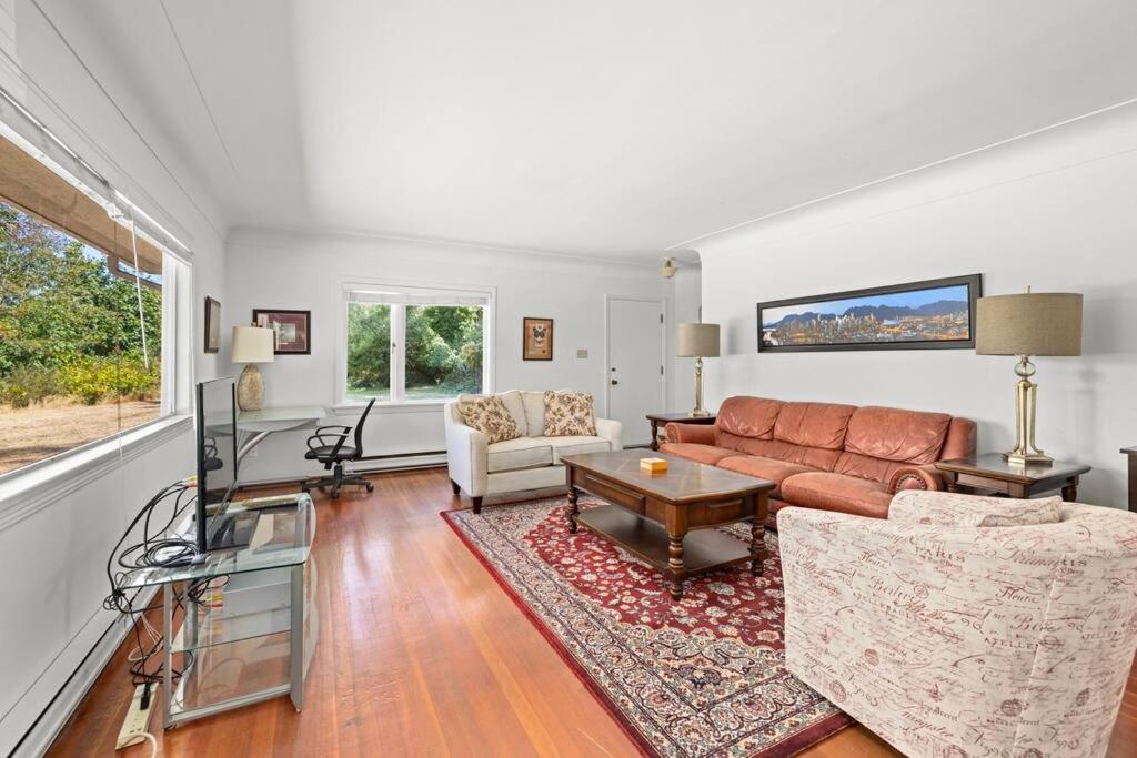 a living room with a couch and a table at Seaside Country Cottage in Saanichton