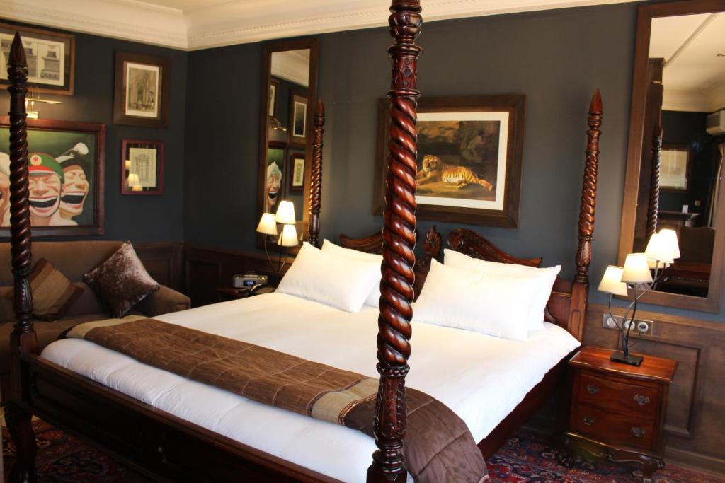 a bedroom with a four poster bed and a couch at Le Loft in Bamako